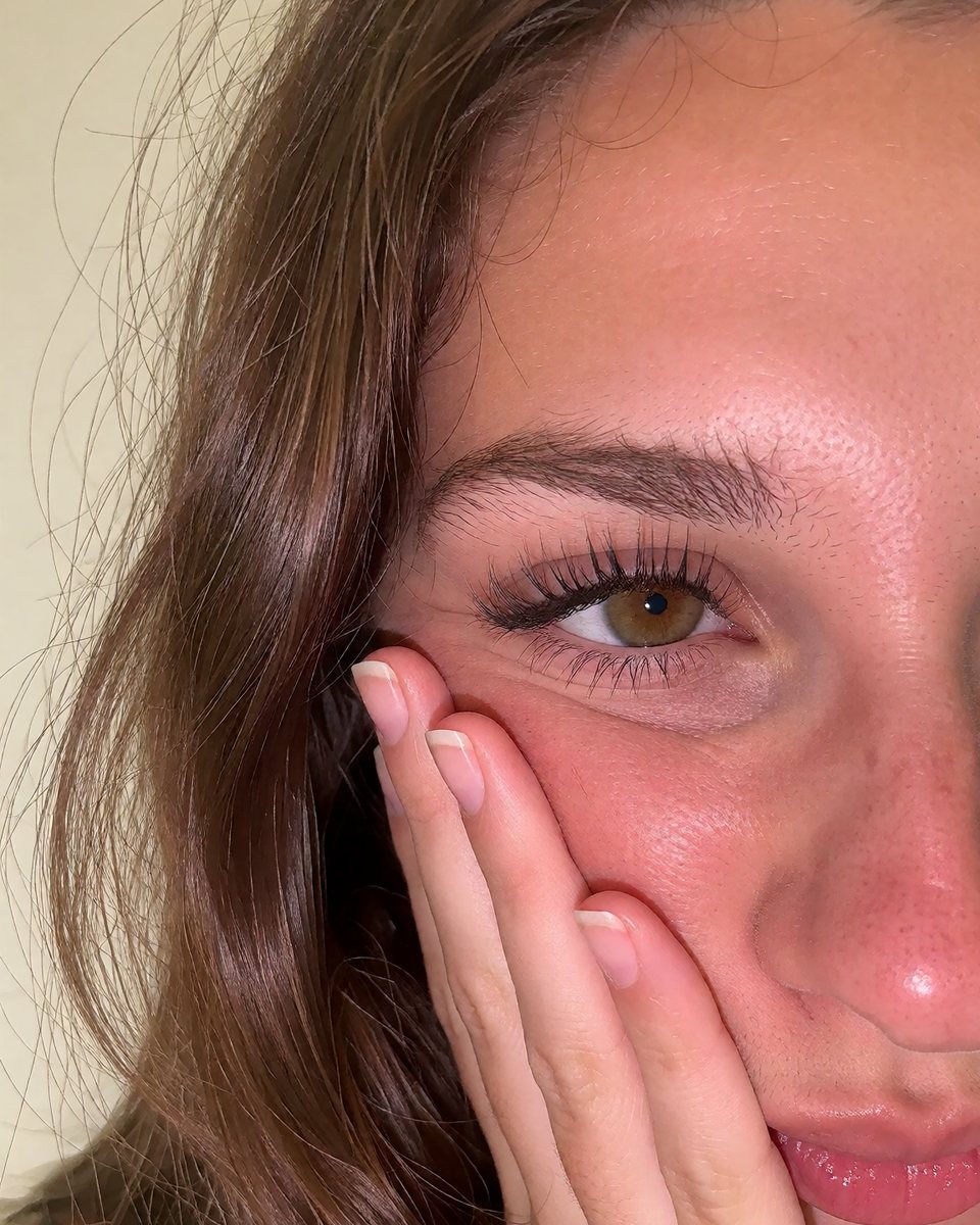 Result of a 25-word prompt: a close-up of half a woman's face, her hand on her cheek.